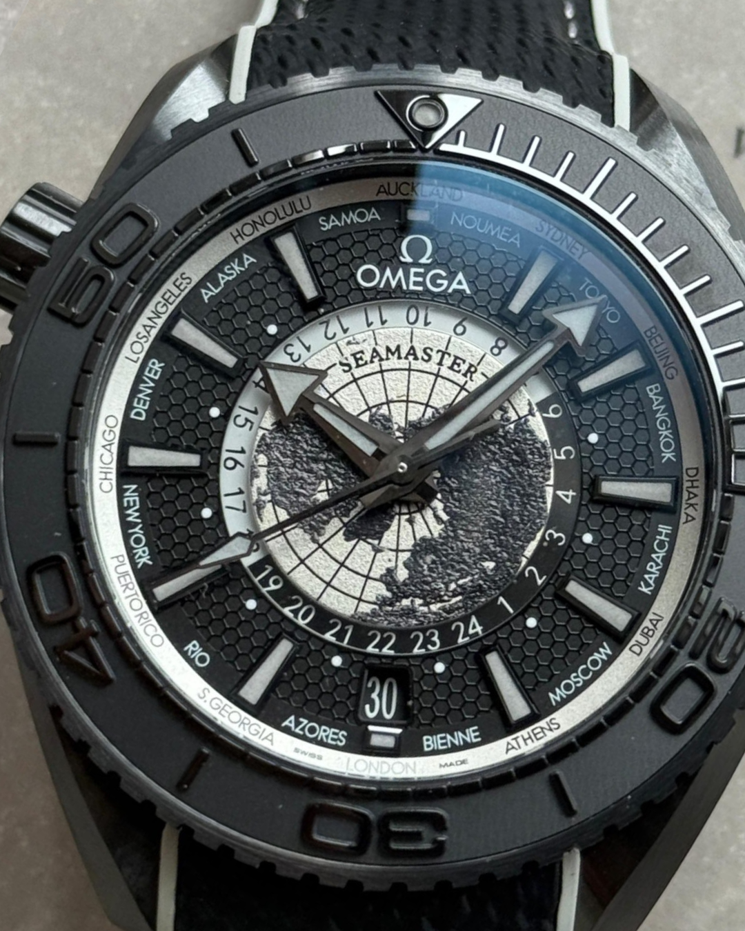 Omega Planet Ocean 45.5mm GMT black world timer watch with detailed dial and multiple time zones