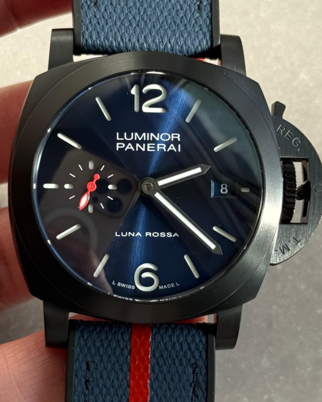 Luminor 40mm Luna Rossa watch with DLC black case, blue dial, and dark blue rubber textile strap
