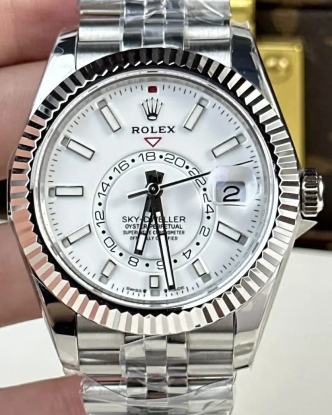 Close-up of Sky Dweller Watch with white dial, oystersteel and 18k white gold bezel, stainless steel bracelet, and date display.