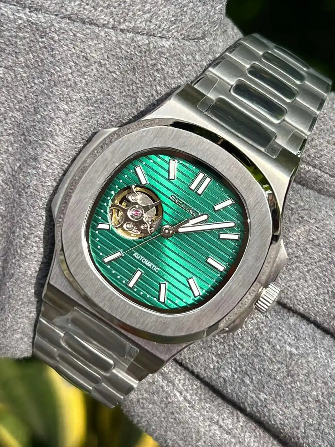 Silver wristwatch with green face.